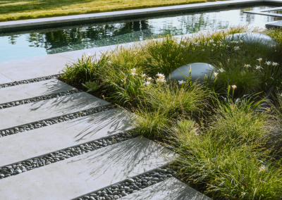 Penning Landscapes maintenance: lush plantings and stone pathways around a pool area.