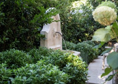 Stone fountain and lush plantings in a Penning Landscapes maintenance project